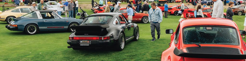 Porsche 911s at outdoor car show on green grass
