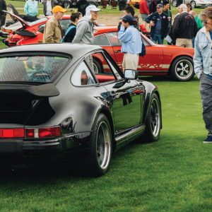 Porsche 911s at outdoor car show on green grass