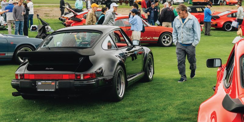 Porsche 911s at outdoor car show on green grass